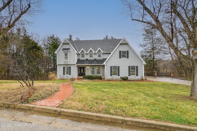 view of front of home with a front lawn and roof with shingles