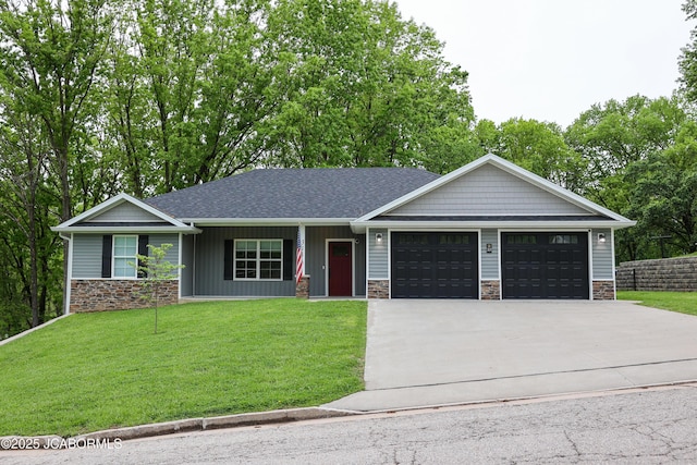 ranch-style home with an attached garage, concrete driveway, a front lawn, and stone siding