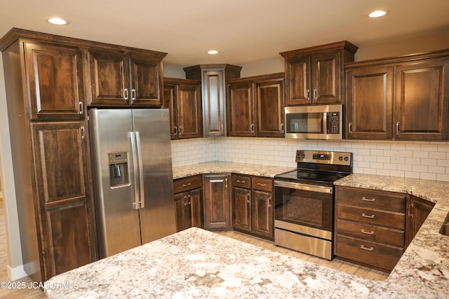 kitchen featuring appliances with stainless steel finishes, dark brown cabinetry, recessed lighting, and light stone counters