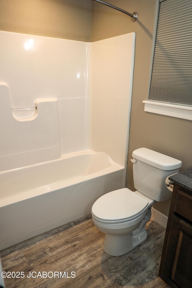 full bath with vanity, shower / bathtub combination, toilet, and wood finished floors