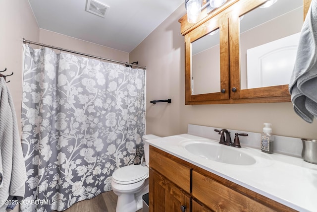 full bathroom featuring visible vents, toilet, a shower with curtain, wood finished floors, and vanity