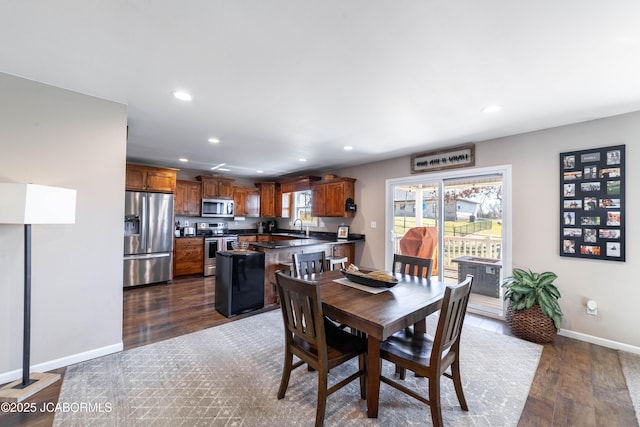 dining area featuring dark wood finished floors, recessed lighting, and baseboards