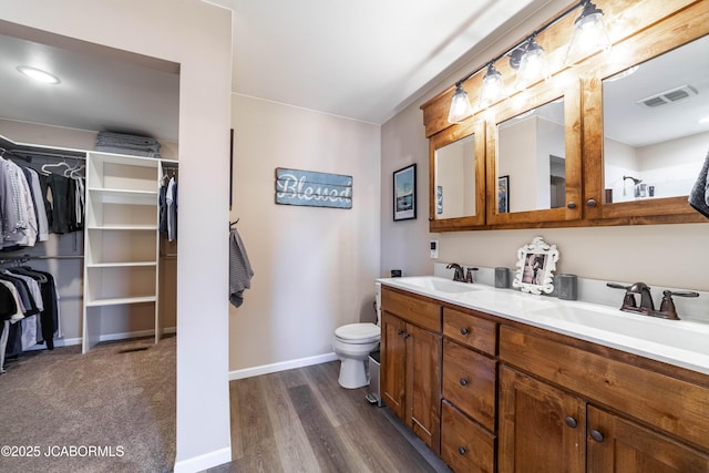 bathroom with a sink, visible vents, baseboards, and double vanity