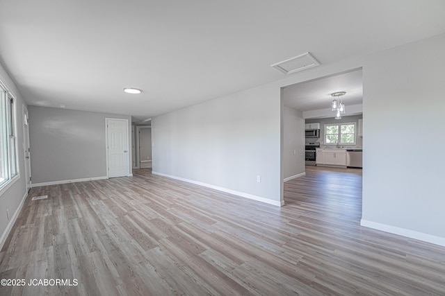 115 Middle St, Moberly, MO 65270 - unfurnished room featuring light wood-style floors, baseboards, a sink, and attic access