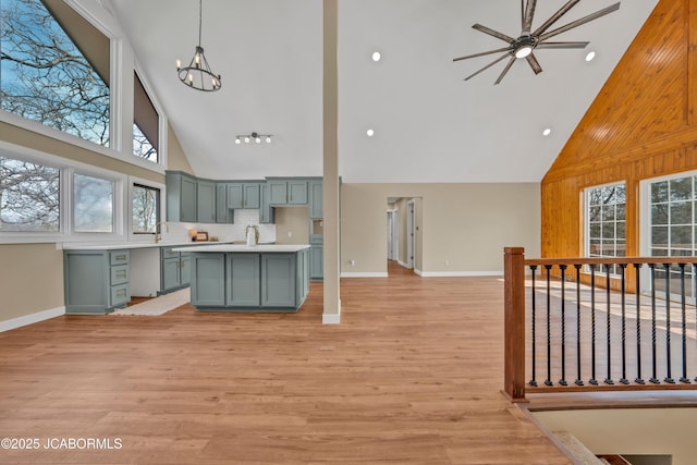 160 Ravenwood Dr, Camdenton, MO 65020 - kitchen featuring high vaulted ceiling, light wood-style flooring, light countertops, ceiling fan with notable chandelier, and open floor plan