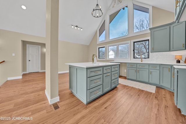 160 Ravenwood Dr, Camdenton, MO 65020 - kitchen with baseboards, visible vents, high vaulted ceiling, light countertops, and light wood-type flooring