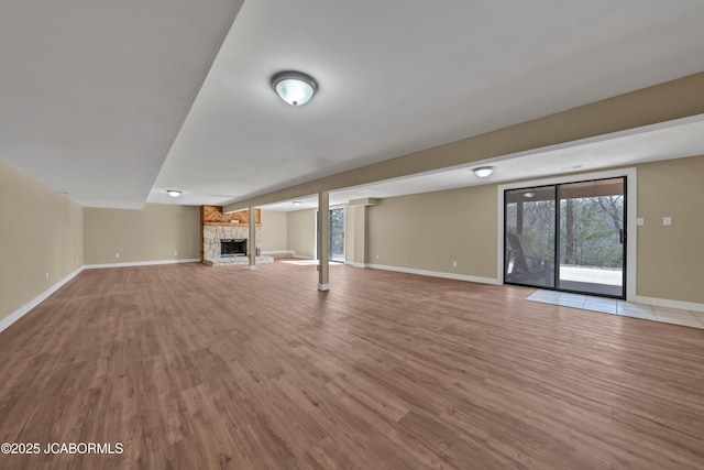 160 Ravenwood Dr, Camdenton, MO 65020 - below grade area with a stone fireplace, baseboards, and wood finished floors