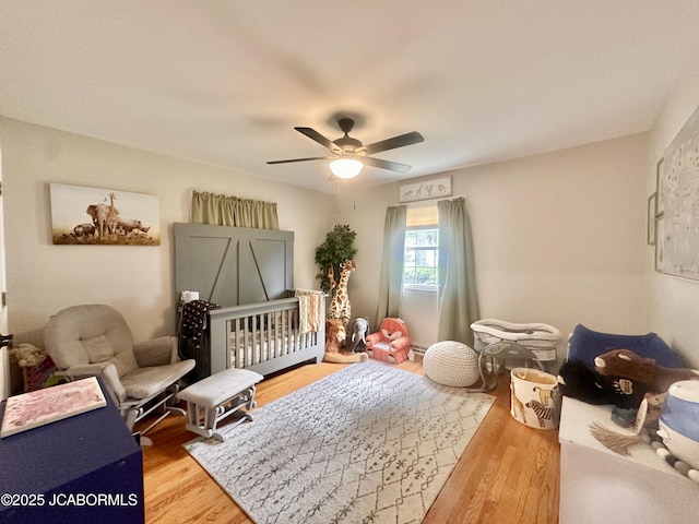 405 Lorene St, California, MO 65018 - bedroom featuring a crib, wood finished floors, and a ceiling fan