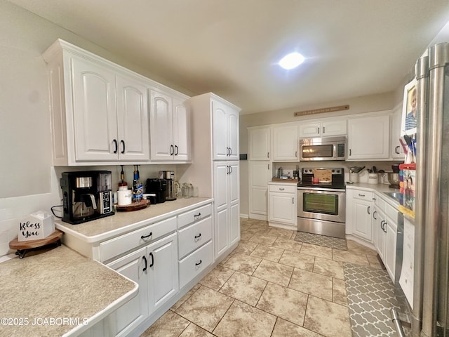 405 Lorene St, California, MO 65018 - kitchen with appliances with stainless steel finishes, white cabinetry, and light countertops