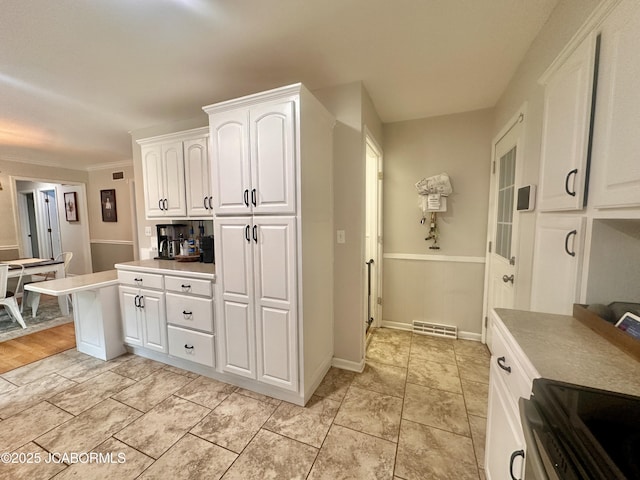 405 Lorene St, California, MO 65018 - kitchen featuring white cabinetry, light countertops, stainless steel electric range oven, and ornamental molding