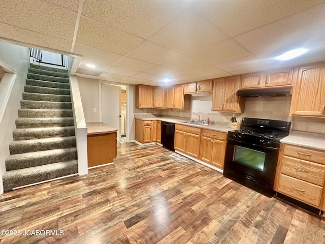 405 Lorene St, California, MO 65018 - kitchen with black appliances, under cabinet range hood, light wood-type flooring, light countertops, and a drop ceiling