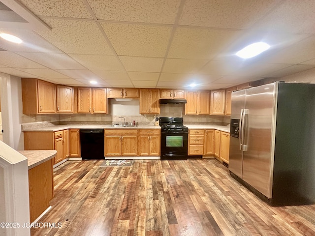 405 Lorene St, California, MO 65018 - kitchen featuring black appliances, light wood-style floors, under cabinet range hood, light countertops, and a paneled ceiling