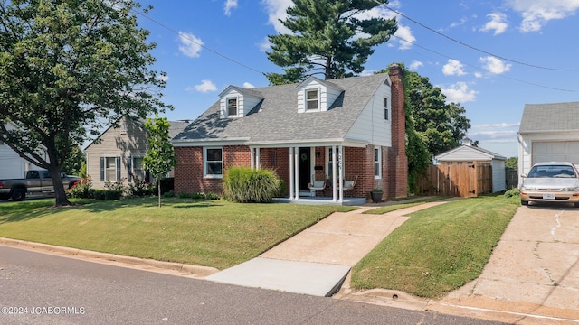 new england style home featuring a porch, a garage, and a front lawn