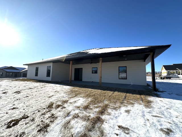 view of snow covered back of property