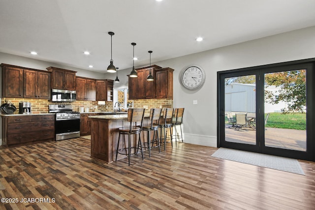 140 County Road 412, Fayette, MO 65248 - kitchen with appliances with stainless steel finishes, dark wood-style floors, tasteful backsplash, a peninsula, and recessed lighting