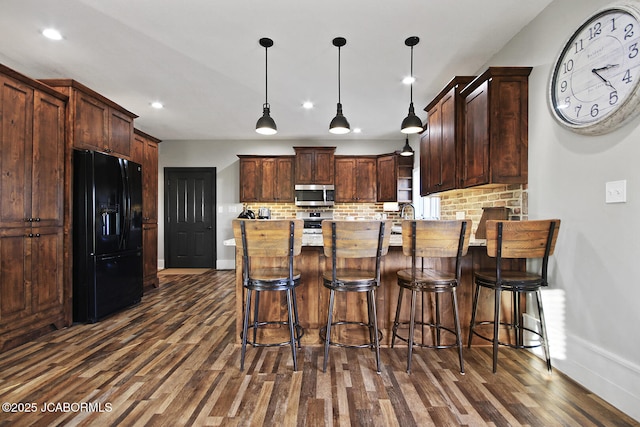 140 County Road 412, Fayette, MO 65248 - kitchen with stainless steel microwave, black fridge, a peninsula, baseboards, and dark wood finished floors