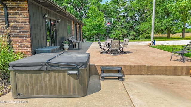 140 County Road 412, Fayette, MO 65248 - view of patio / terrace featuring a hot tub, outdoor dining area, and view of wooded area