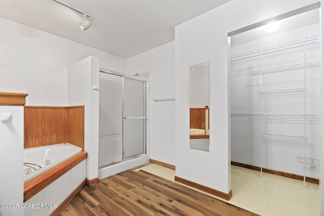 3861 State Road H, Fulton, MO 65251 - full bathroom featuring a stall shower, a bath, a walk in closet, and wood finished floors