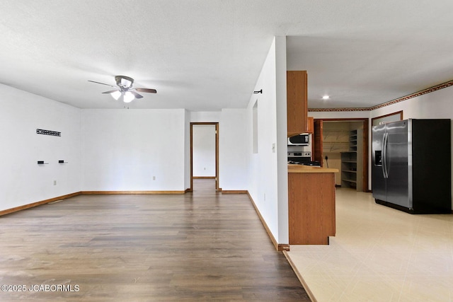 3861 State Road H, Fulton, MO 65251 - kitchen featuring stainless steel appliances, ceiling fan, brown cabinets, light wood-style flooring, and open floor plan
