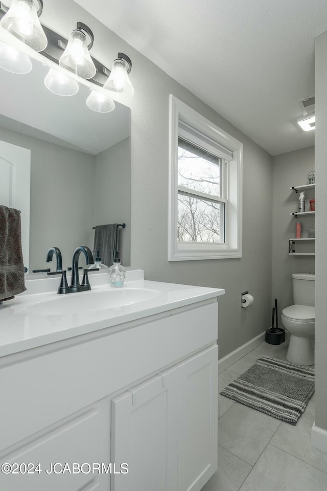 bathroom with tile patterned flooring, vanity, and toilet