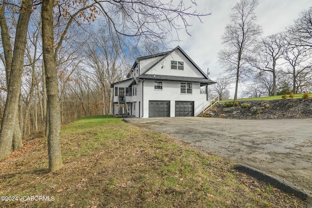 view of home's exterior with a garage and a lawn