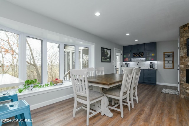 dining space with dark hardwood / wood-style flooring, plenty of natural light, and indoor bar