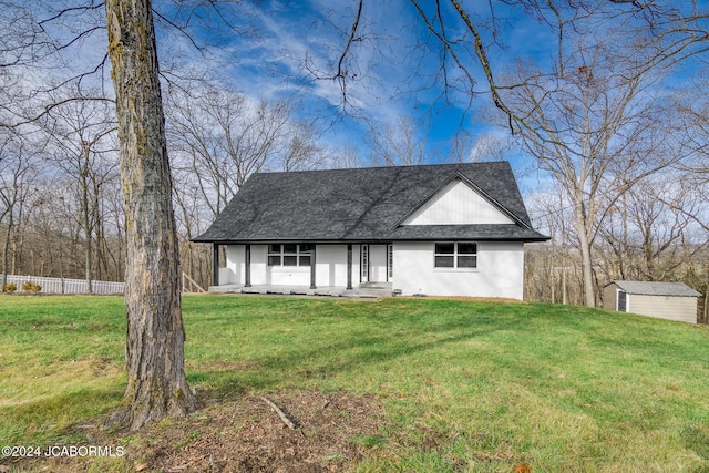 view of front facade with a front yard and a storage shed