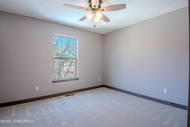 empty room featuring a textured ceiling, ceiling fan, and carpet flooring