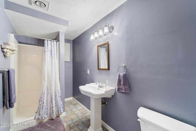 1548 Skyview, Holts Summit, MO 65043 - bathroom featuring toilet, baseboards, a shower with shower curtain, and stone finish floors