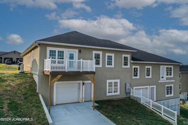 view of front of house with roof with shingles, driveway, stucco siding, a front lawn, and a garage