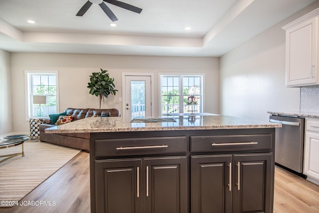 kitchen featuring stainless steel dishwasher, white cabinetry, a kitchen island with sink, and light hardwood / wood-style flooring