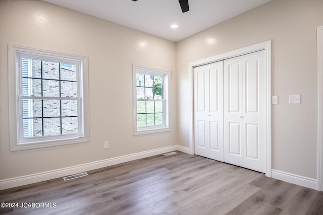 unfurnished bedroom featuring ceiling fan, a closet, and light hardwood / wood-style flooring