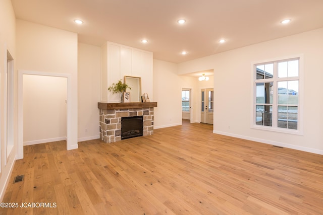 living room featuring baseboards, a fireplace, recessed lighting, visible vents, and light wood finished floors