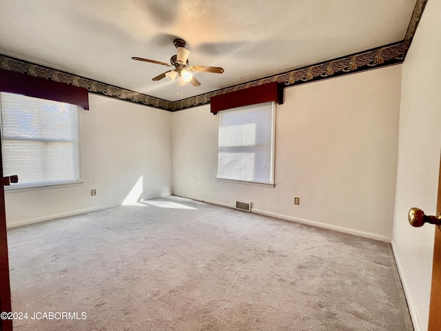 unfurnished room with ceiling fan and light colored carpet