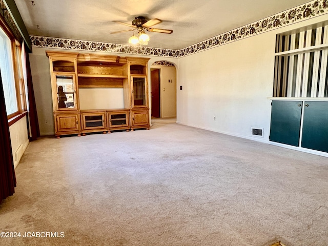 unfurnished living room featuring ceiling fan and light colored carpet