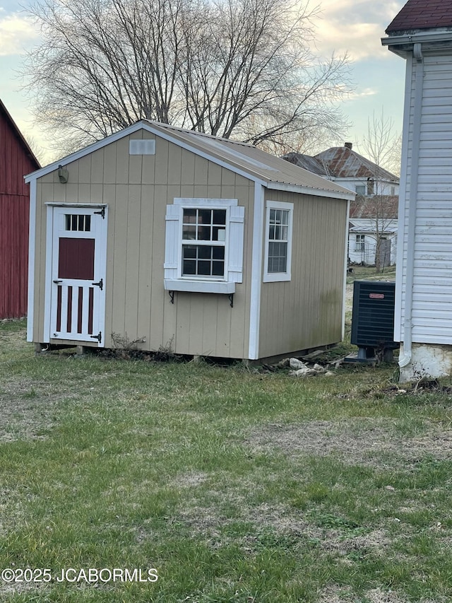 view of outdoor structure featuring a yard and central AC unit