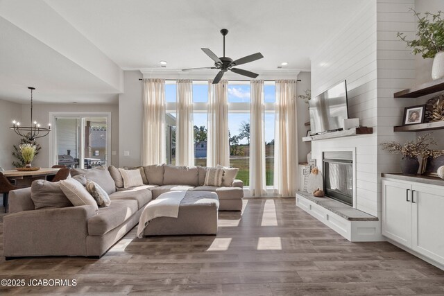 15005 Wrangle Ln, Ashland, MO 65010 - living room featuring ceiling fan with notable chandelier, a large fireplace, ornamental molding, and wood finished floors