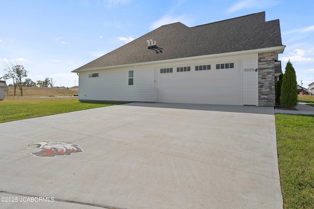 15005 Wrangle Ln, Ashland, MO 65010 - view of side of home with concrete driveway, roof with shingles, a yard, stone siding, and an attached garage