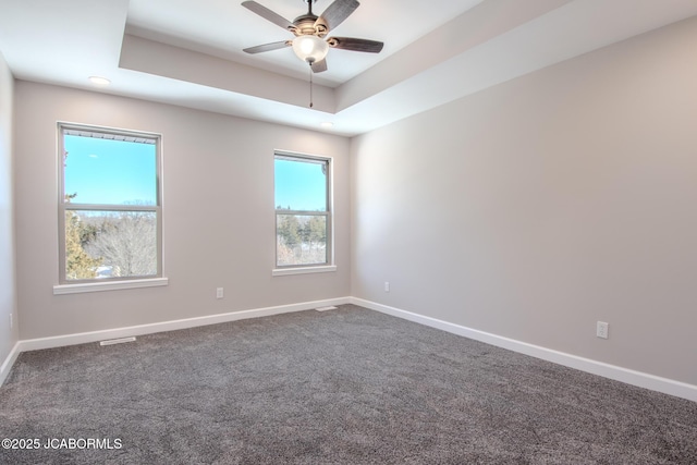 carpeted empty room featuring ceiling fan and a tray ceiling