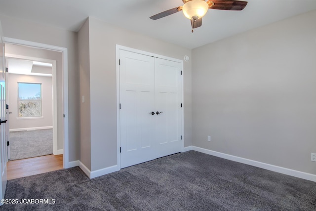 unfurnished bedroom featuring ceiling fan, a closet, and dark colored carpet