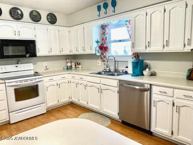 kitchen with stainless steel dishwasher, sink, white range with electric cooktop, and light wood-type flooring