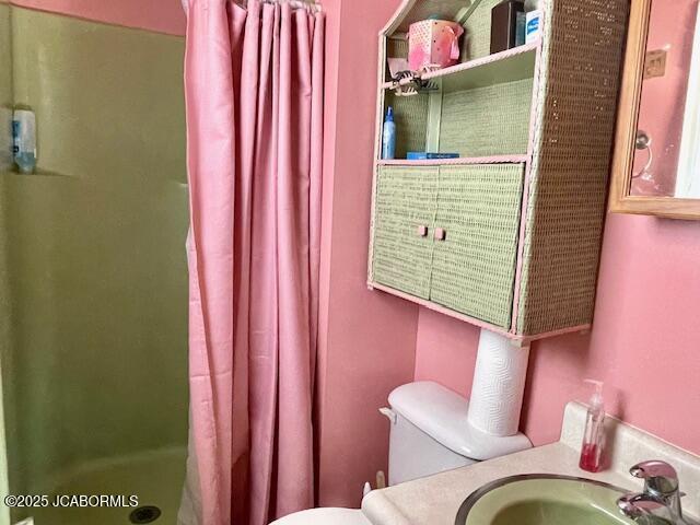 bathroom featuring toilet, a shower with shower curtain, and vanity