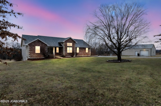 31500 Skyline Dr, California, MO 65018 - view of front facade with an outdoor structure, a lawn, brick siding, a garage, and roof with shingles