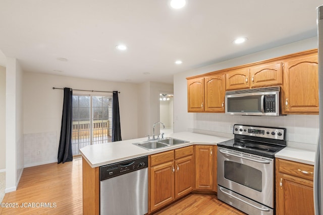 31500 Skyline Dr, California, MO 65018 - kitchen featuring appliances with stainless steel finishes, light wood finished floors, a peninsula, light countertops, and recessed lighting