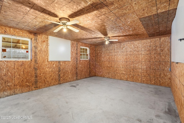 31500 Skyline Dr, California, MO 65018 - spare room featuring unfinished concrete flooring, ceiling fan, and wooden walls