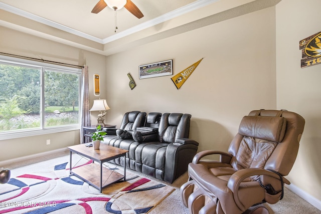 carpeted living room featuring a raised ceiling, ceiling fan, and crown molding