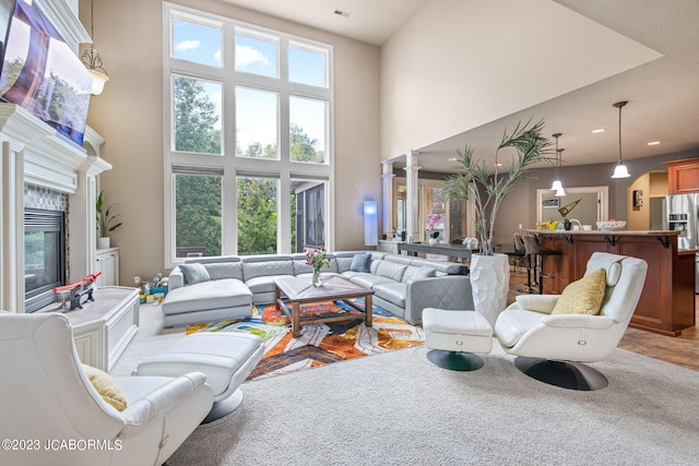 living room featuring a tile fireplace and a high ceiling