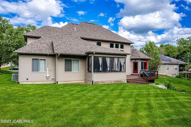 rear view of house with a lawn, a sunroom, and a deck