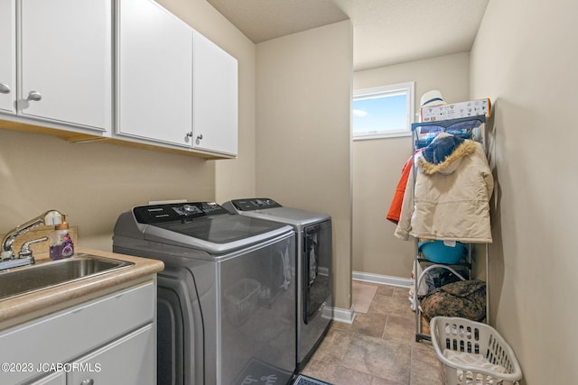 laundry area featuring cabinets, separate washer and dryer, and sink