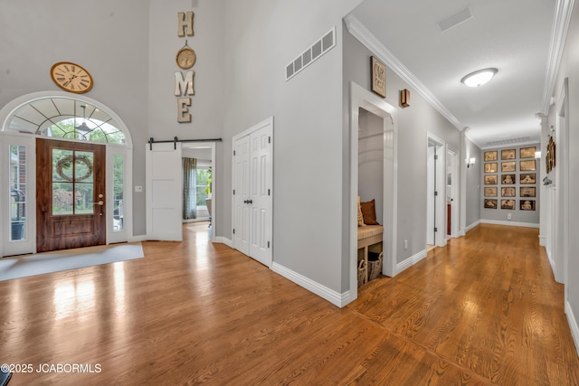 1503 State Highway Z, Centertown, MO 65023 - entrance foyer with crown molding, a barn door, wood finished floors, and baseboards